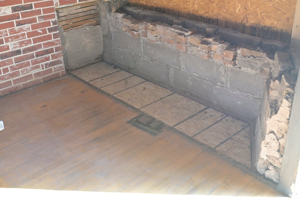 Brewery interior with red brick walls and concrete floor showing the extent of the water damage and foundation repair needed