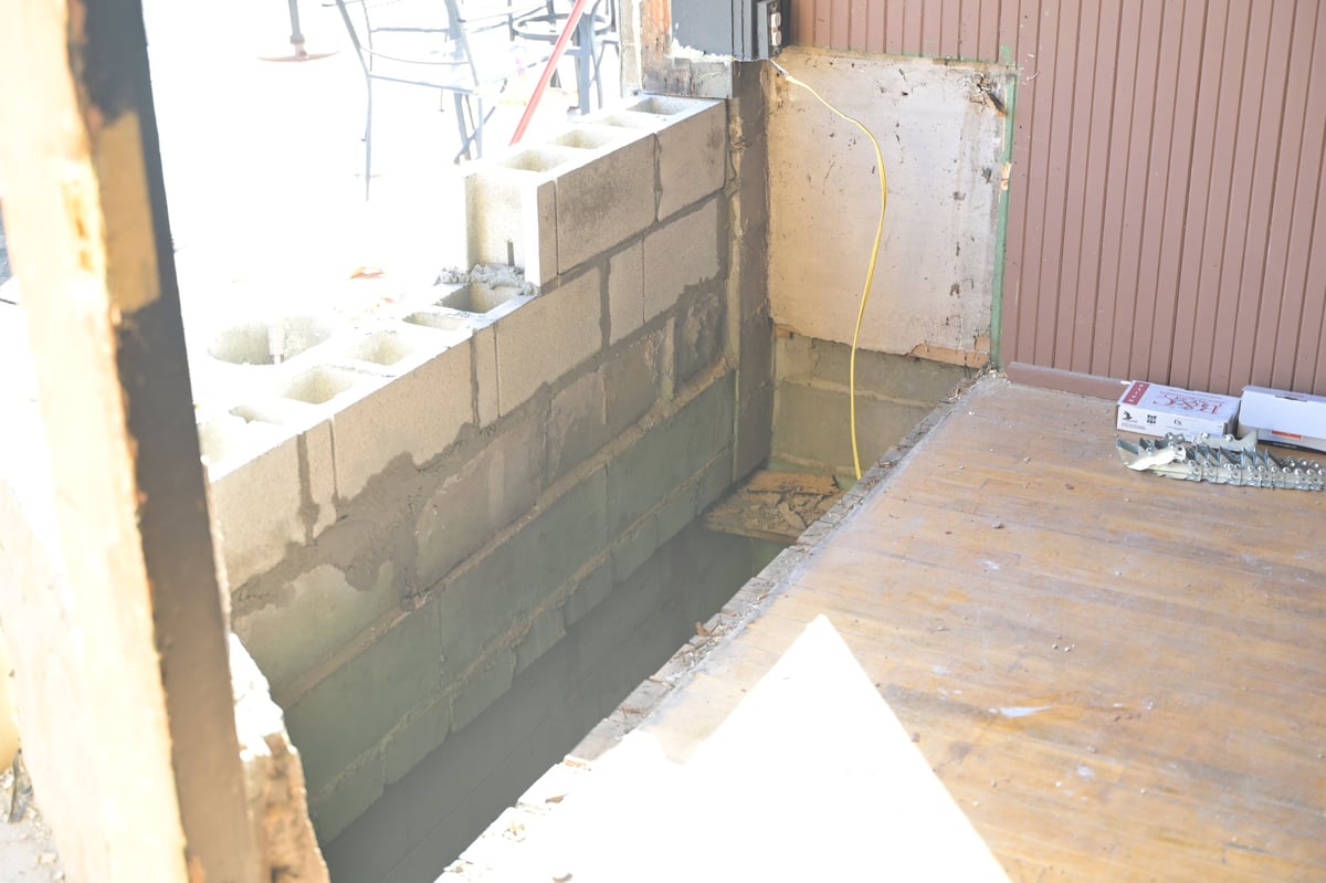 Unfinished brewery interior with new concrete block wall construction and wooden flooring being replaced after the accident