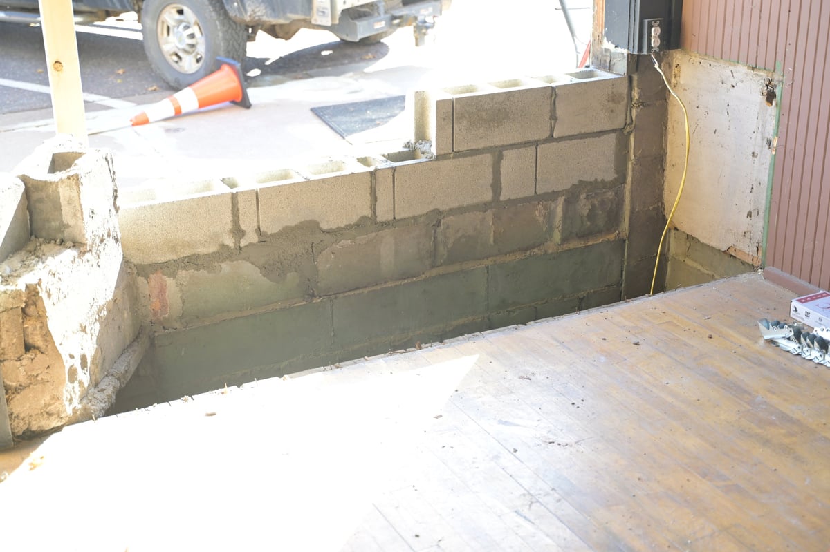 Brewery foundation and floor framing exposed after the collision damage, showing concrete block wall repairs in progress
