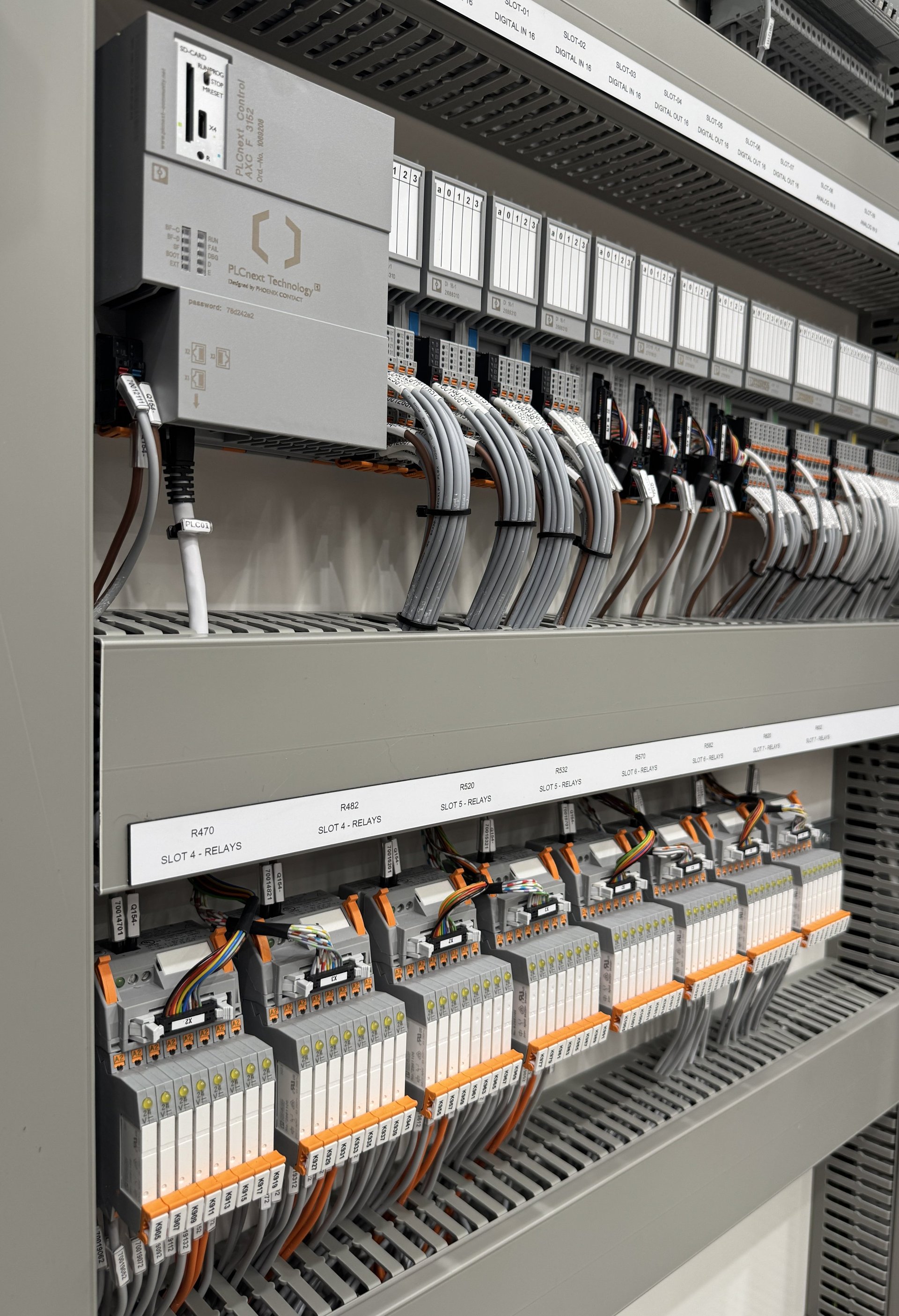 Industrial electrical control panel with organized wiring, circuit breakers, and modular components mounted in a metal enclosure