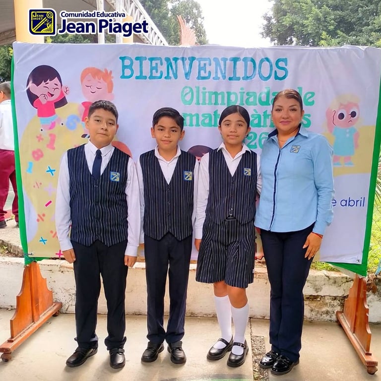 Four people standing in front of a welcome banner for Jean Piaget schools math olympiad event