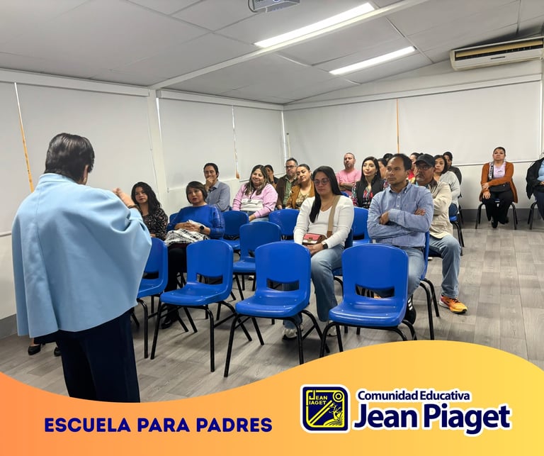 Group of parents and educators sitting in blue chairs at a training session in a classroom, with an instructor speaking to the audience.