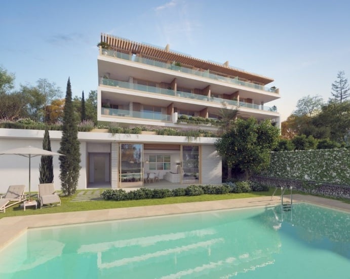 Modern multi-story residential building with pool, featuring white and cream exterior, balconies, ground-level commercial space, and landscaped surroundings