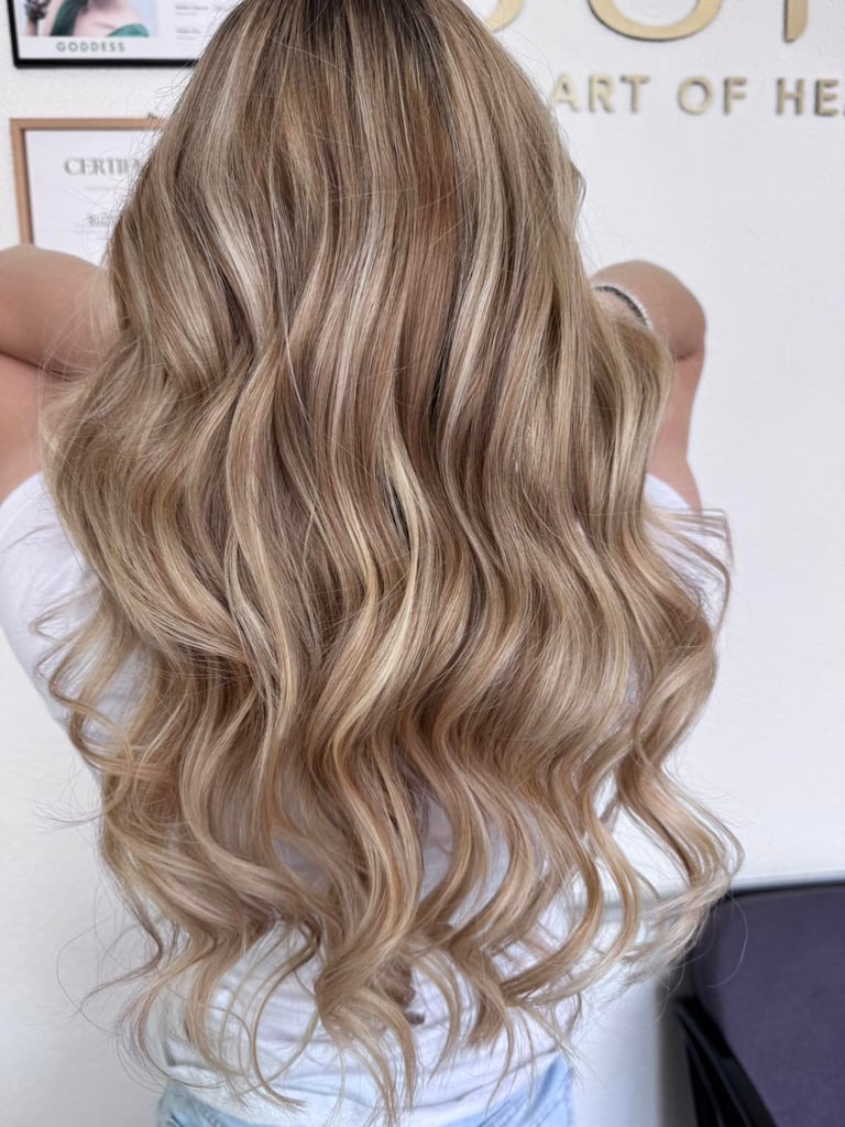 Long wavy blonde hair with highlights shown from behind, styled with soft waves and volume