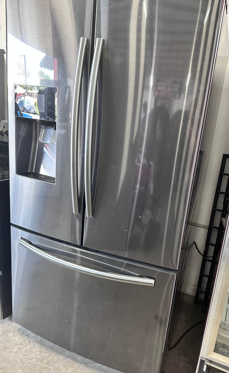 Stainless steel French door refrigerator with ice maker and water dispenser on the door