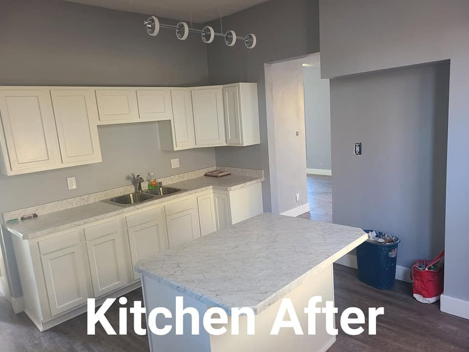 Renovated kitchen with white cabinetry, marble countertop island, and stainless steel appliances