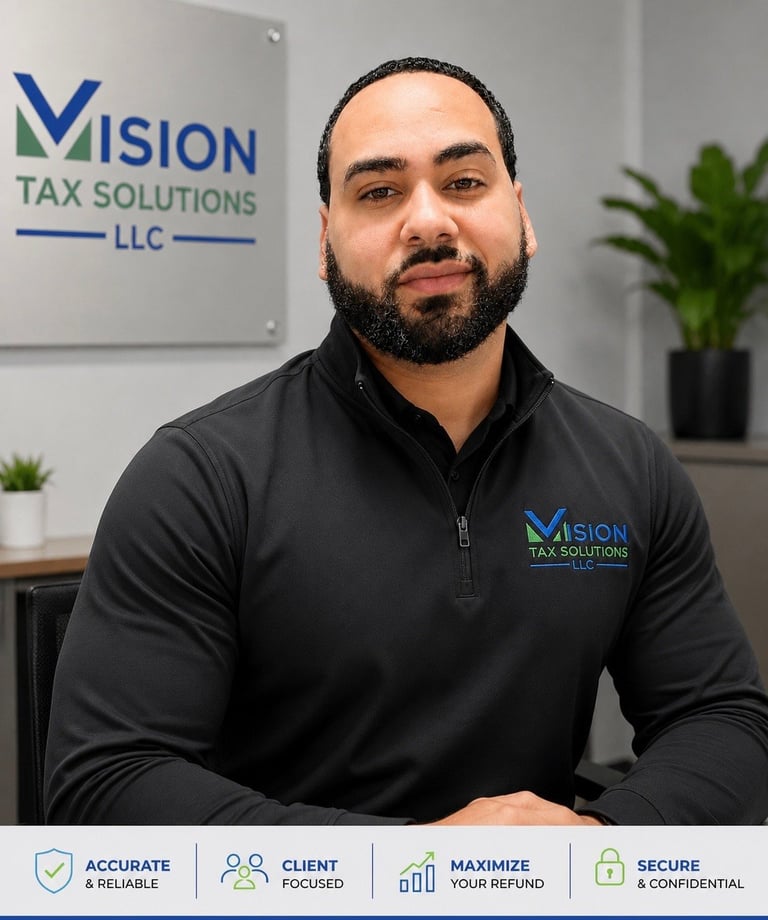 Professional man wearing Vision Tax Solutions branded black jacket in modern office with company logo and tagline visible behind him