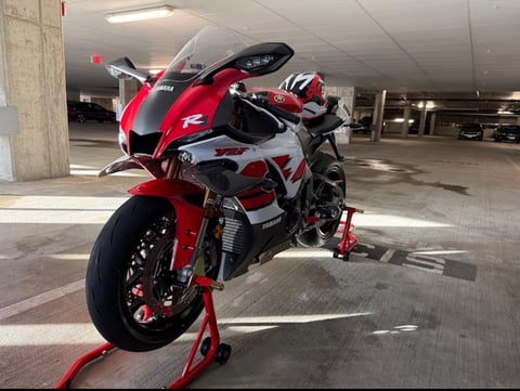 Red and white sports motorcycle on red stand in concrete parking garage