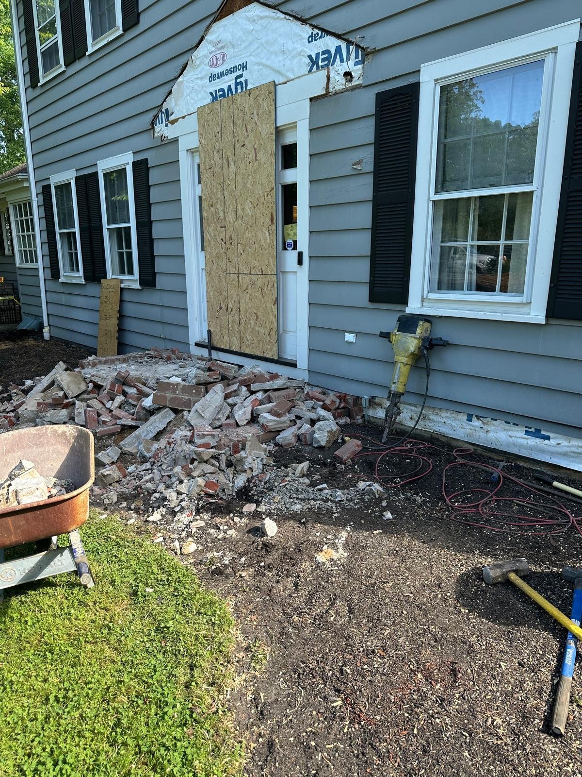 Home with boarded entrance and demolished exterior materials