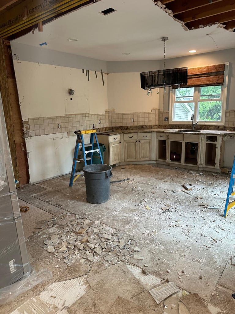 Kitchen renovation with exposed drywall and debris