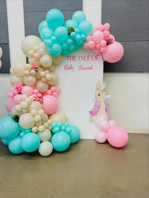 Baby shower backdrop with pastel balloons in turquoise, pink, and cream, Peter Rabbit illustration