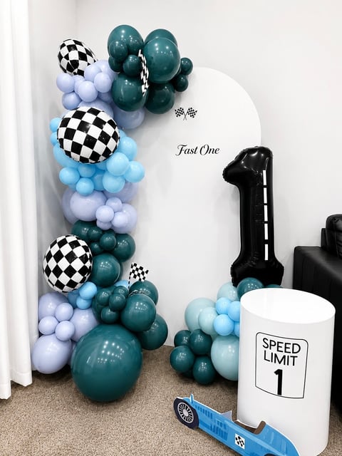 First birthday racing theme party with checkered balloons, teal and blue balloons