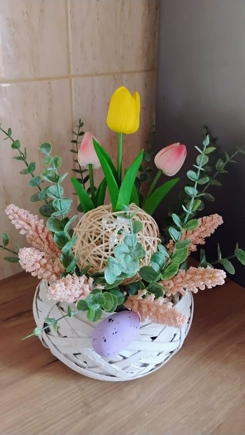 Wiosenna dekoracja z tulipanami w wiklinowym koszyku