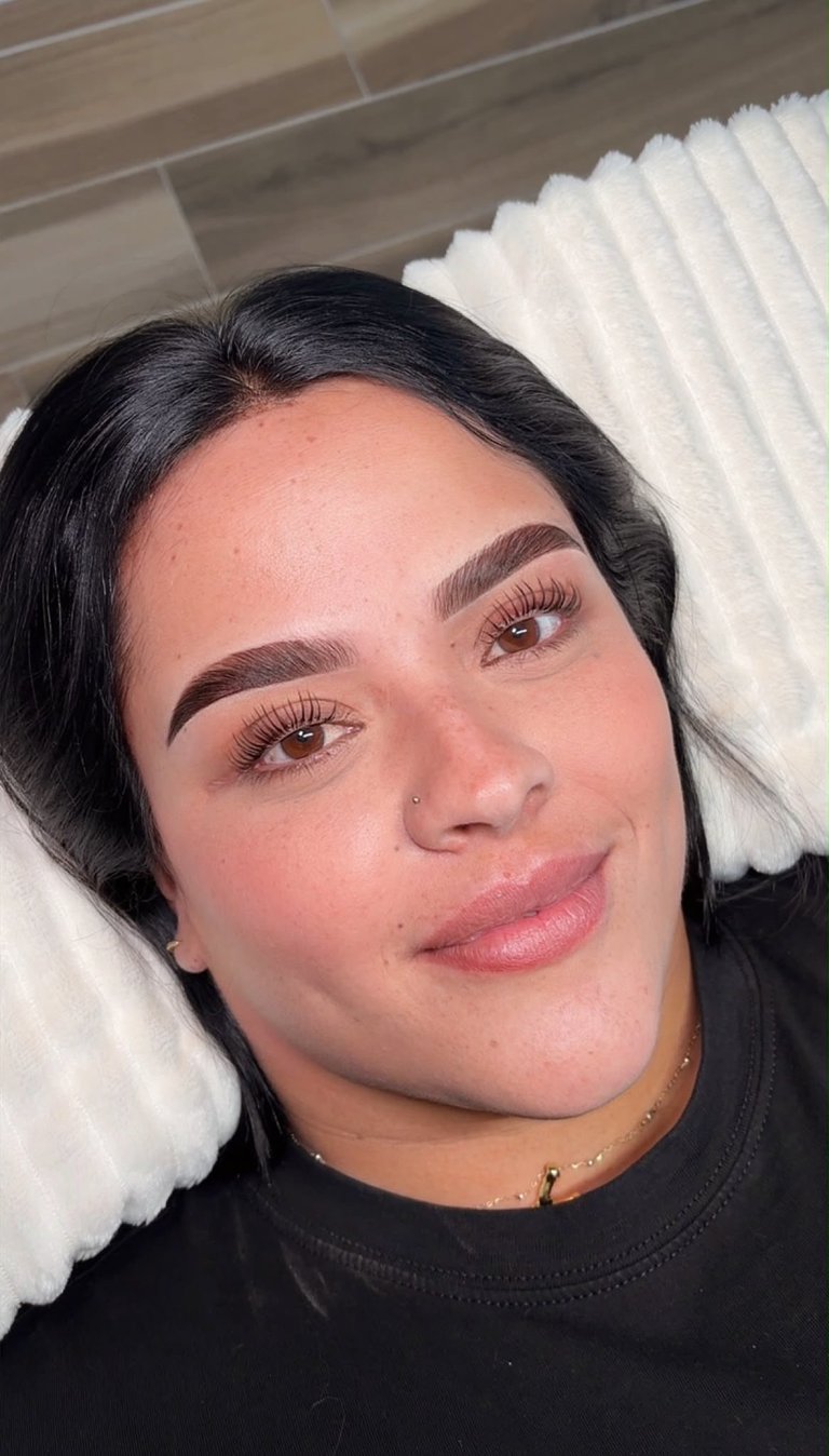 Client result: defined brows and natural lashes, selfie portrait on white pillow