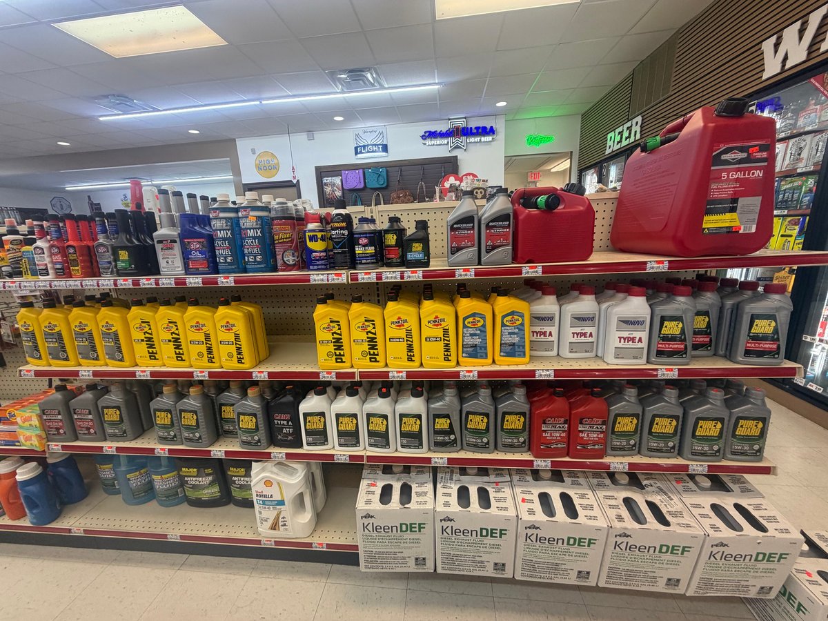 Auto parts store shelves displaying various motor oils, lubricants, and automotive fluids in bottles and containers