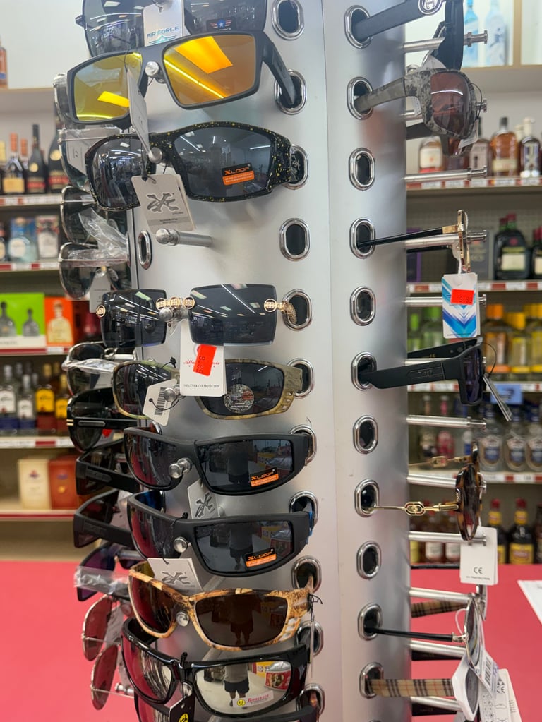 Pegboard display with multiple sunglasses mounted vertically, featuring various styles and colors in the store