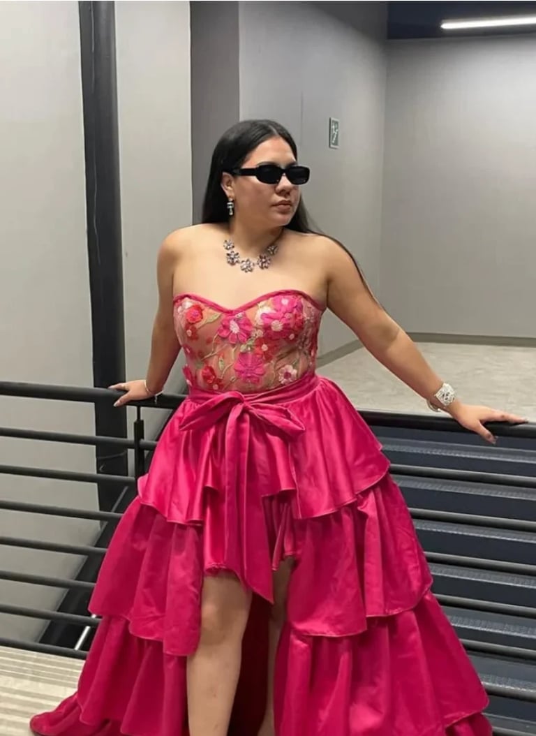 Modelo con vestido de gala rosa fuerte, aplicaciones florales y falda en capas, lentes oscuros y collar de statement, propuesta de KANELICIOUSS de Karen Rodríguez
