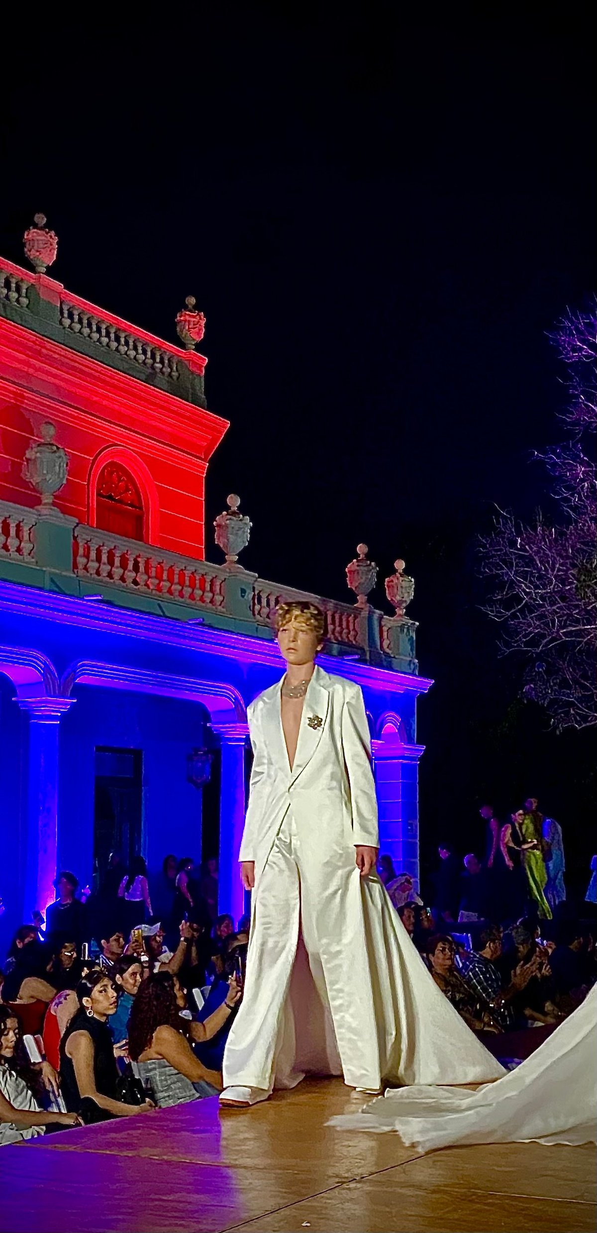 Modelo con vestido largo de seda negra en una pasarela editorial