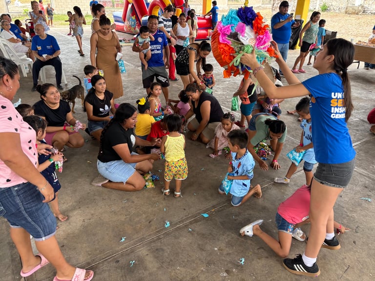 Niños jugando con piñatas de papel de colores en la jornada comunitaria