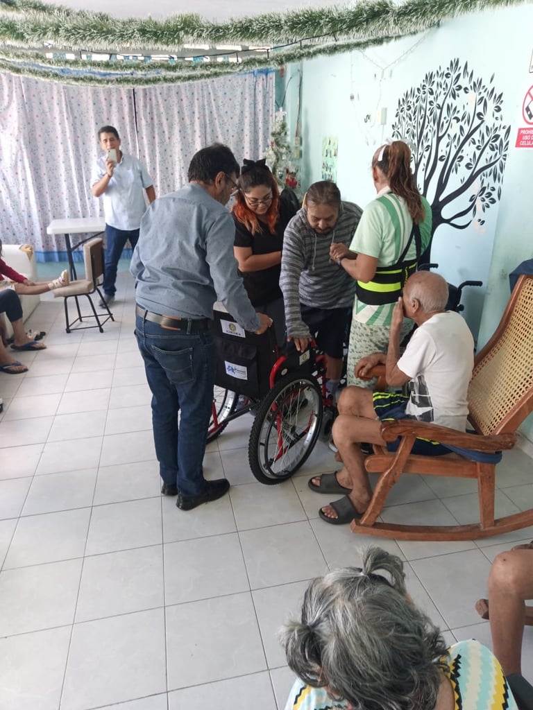 Miembros de la comunidad reunidos examinando juntos una bicicleta roja en un salón o centro comunitario