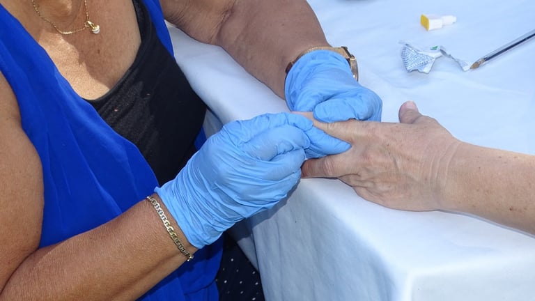 Profesional de la salud examinando la mano de un paciente con guantes azules