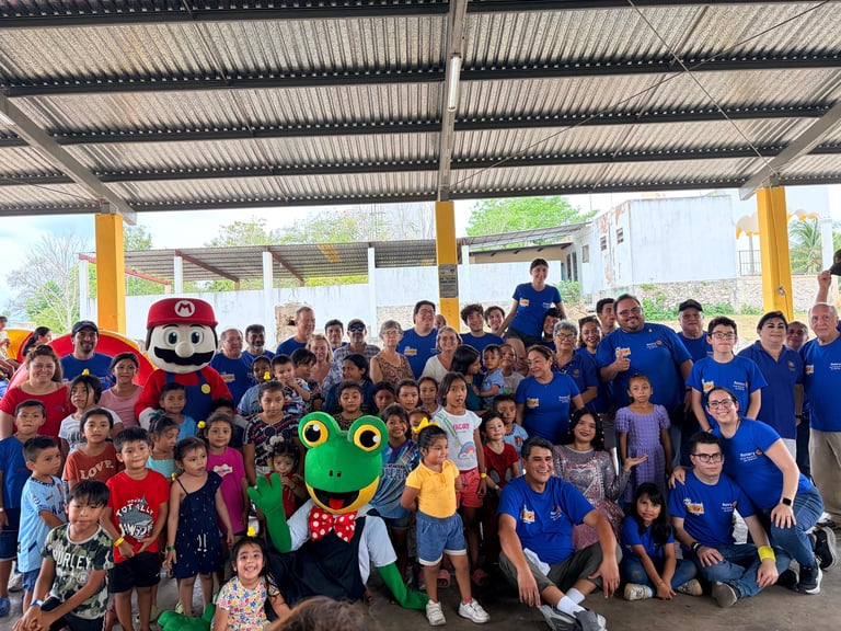 Gran grupo de niños con playera azul posando con personajes disfrazados en Chinkilá