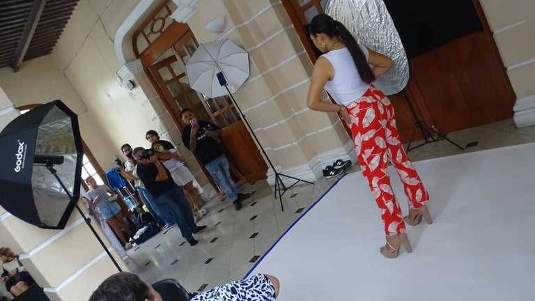 Mujer con pantalón rojo estampado posando frente a un equipo de producción durante una sesión