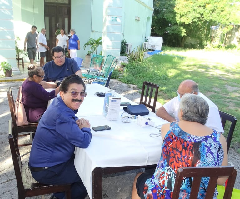 Convivencia al aire libre con asistentes sentados en mesas durante el evento