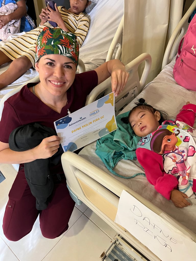 Profesional de la salud con uniforme vino y gorra colorida sosteniendo un certificado junto a una cama pediátrica