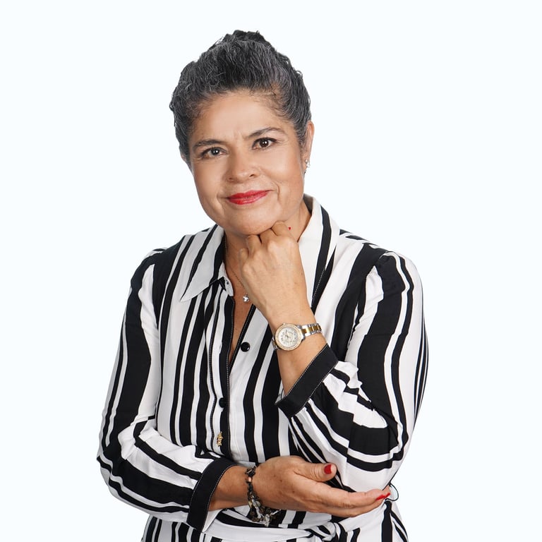 Retrato profesional de una mujer madura con cabello gris, blazer a rayas negras y blancas y reloj, posando con elegancia sobre fondo blanco