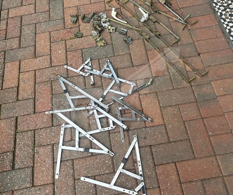 Scattered white PVC pipes and metal materials on brick paving, construction or renovation debris