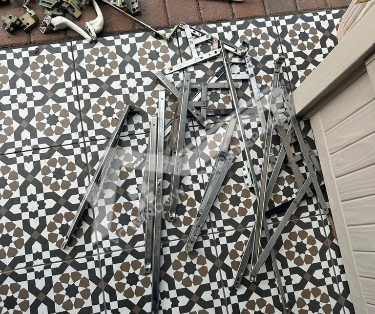 Disassembled bicycle frame and metal parts lying on black and white geometric patterned floor