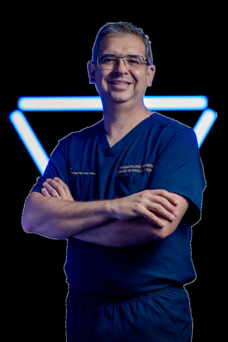 Male healthcare professional in blue scrubs and glasses, arms crossed, standing against neon blue lighting on black background
