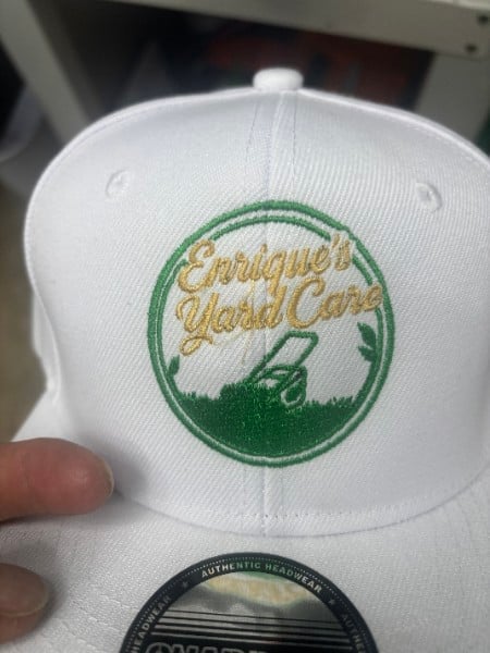 White cap embroidered with a golf club logo