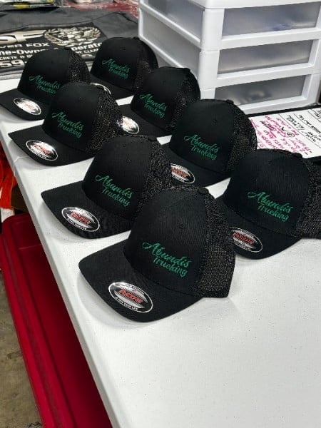 Black mesh trucker caps embroidered with green text