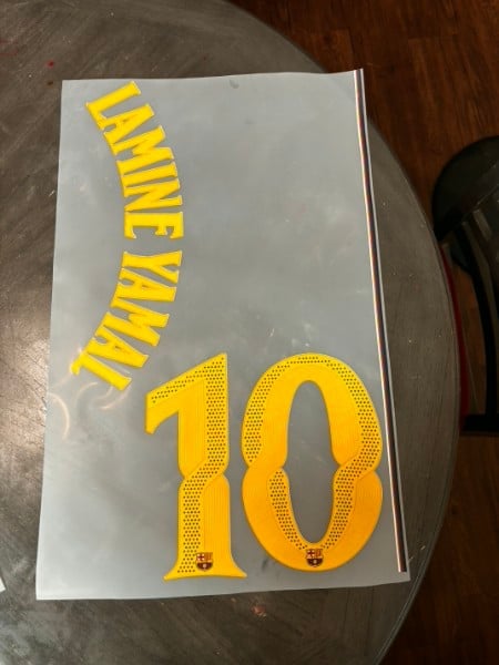 White paper with yellow curved text reading LIVE WHAT YOU LIVE and large number 10 below on wooden surface