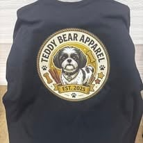 Black sweatshirt printed with a gold circular badge logo