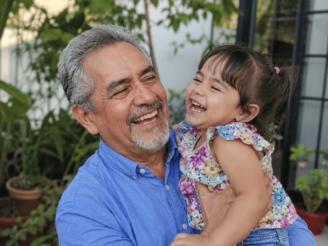 Abuelo cargando a su nieta después de recuperar movilidad con cirugía articular en CDMX