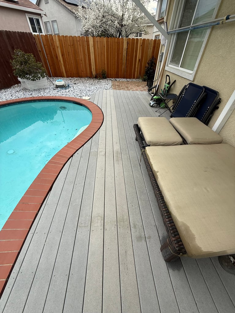 Backyard patio with turquoise pool and weathered gray composite deck