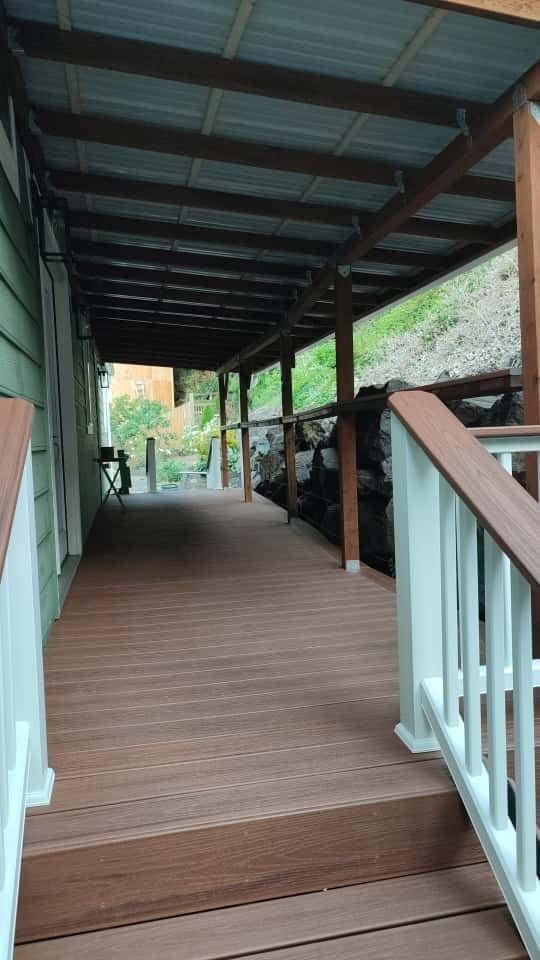New covered deck with dark beam pergola, white railings