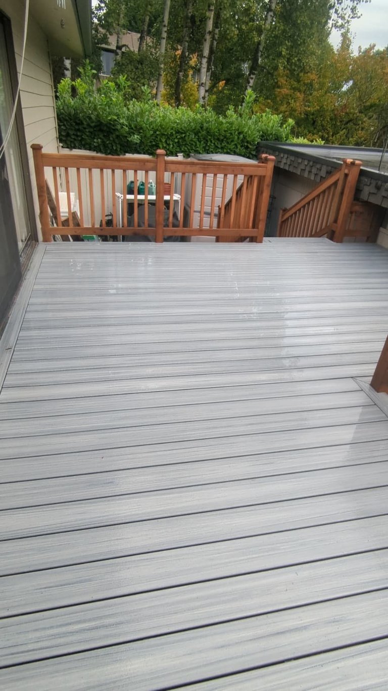 Spacious wooden deck with new brown railings and gate