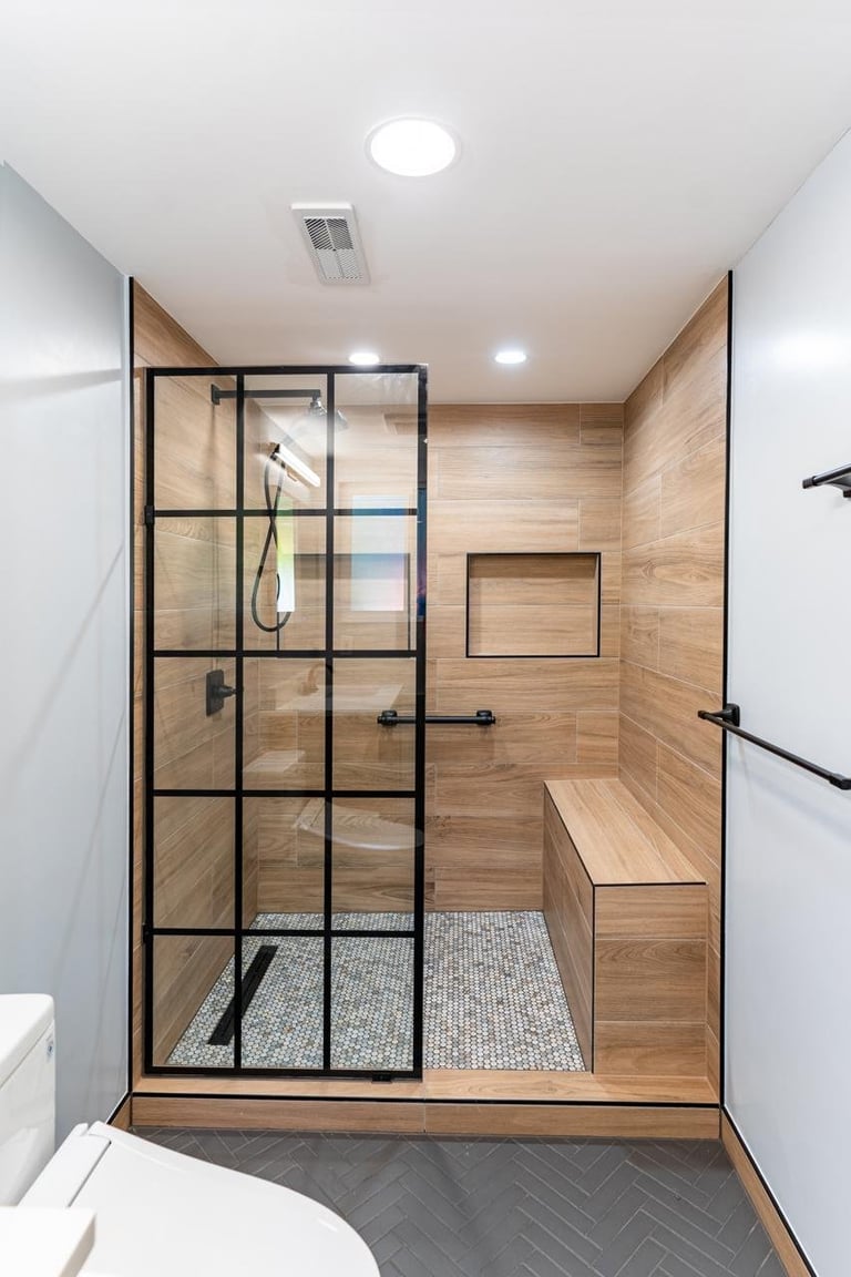 Walk-in shower with black metal grid glass door and wood tile walls