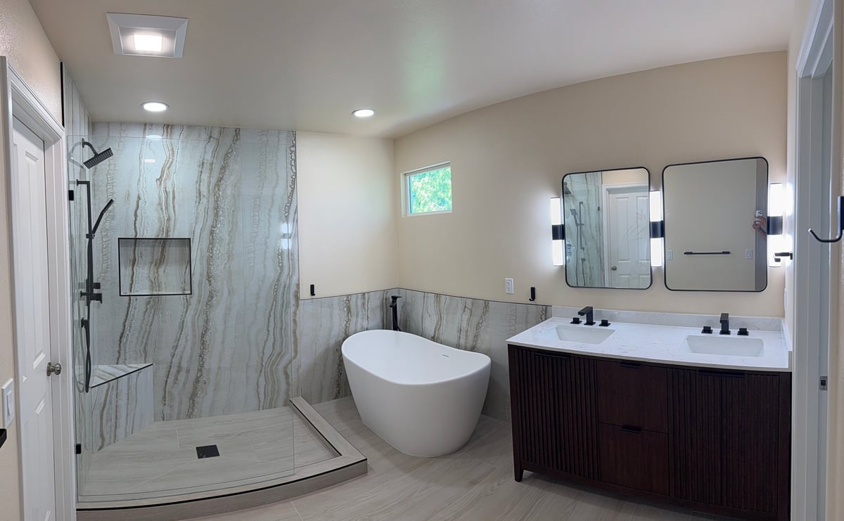 Modern bathroom with walk-in shower, freestanding tub, and dark vanity