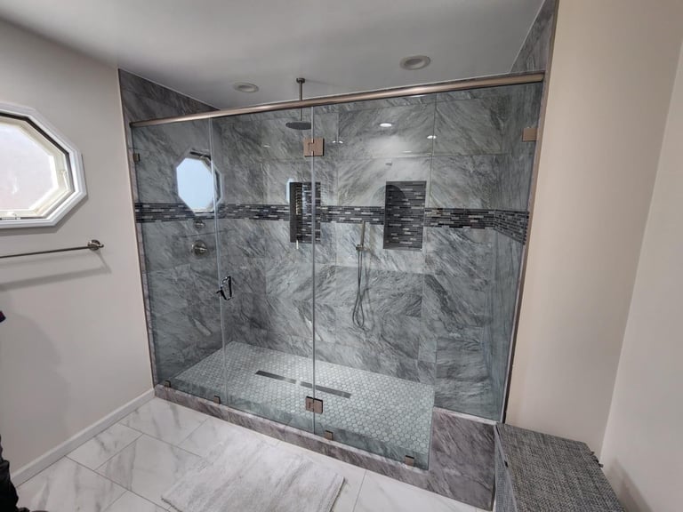 Modern walk-in shower with gray marble tile walls and rain showerhead