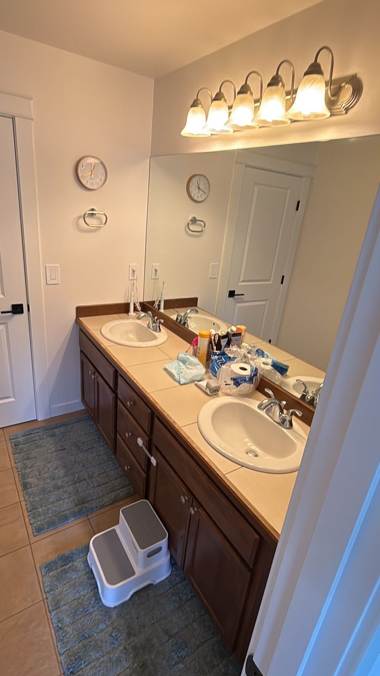 Dated bathroom with double sink vanity and dark cabinets