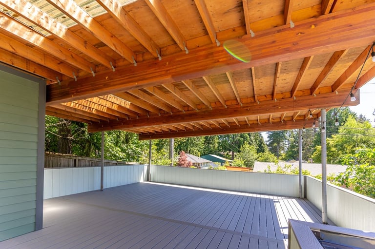 Wooden pergola covering composite deck overlooking neighborhood