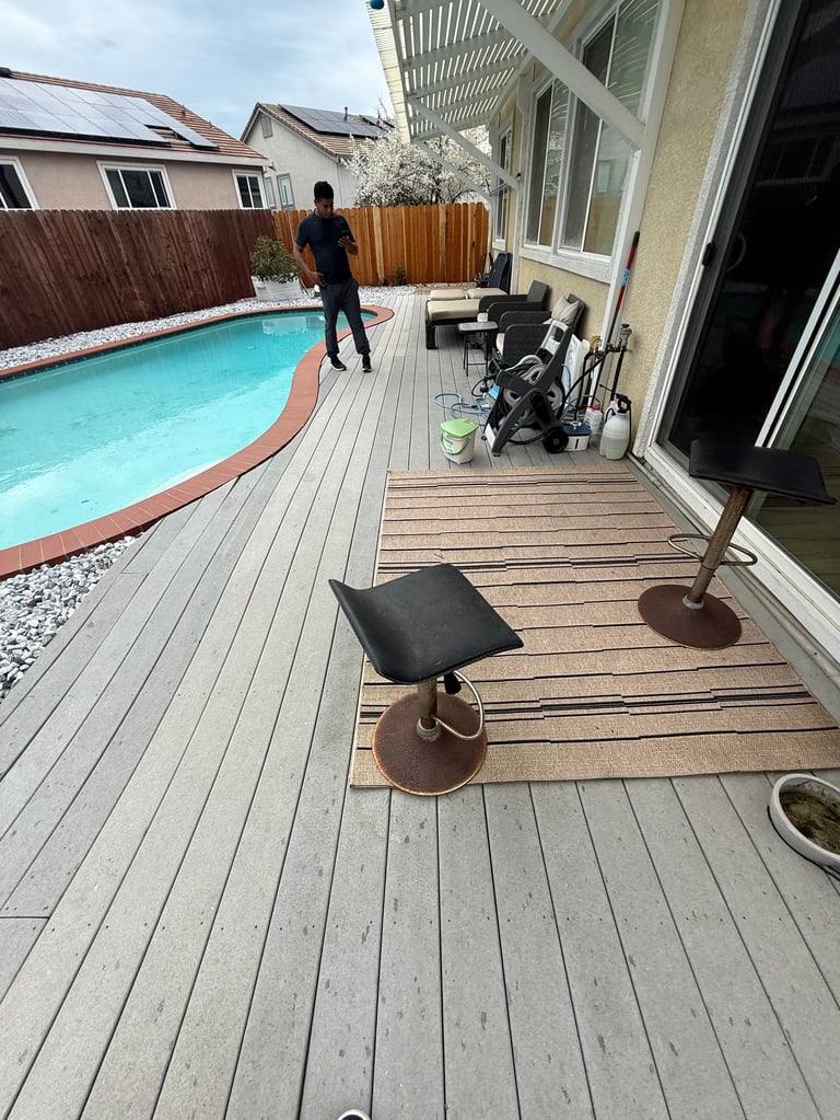 Backyard deck with pool before renovation, person in dark clothing