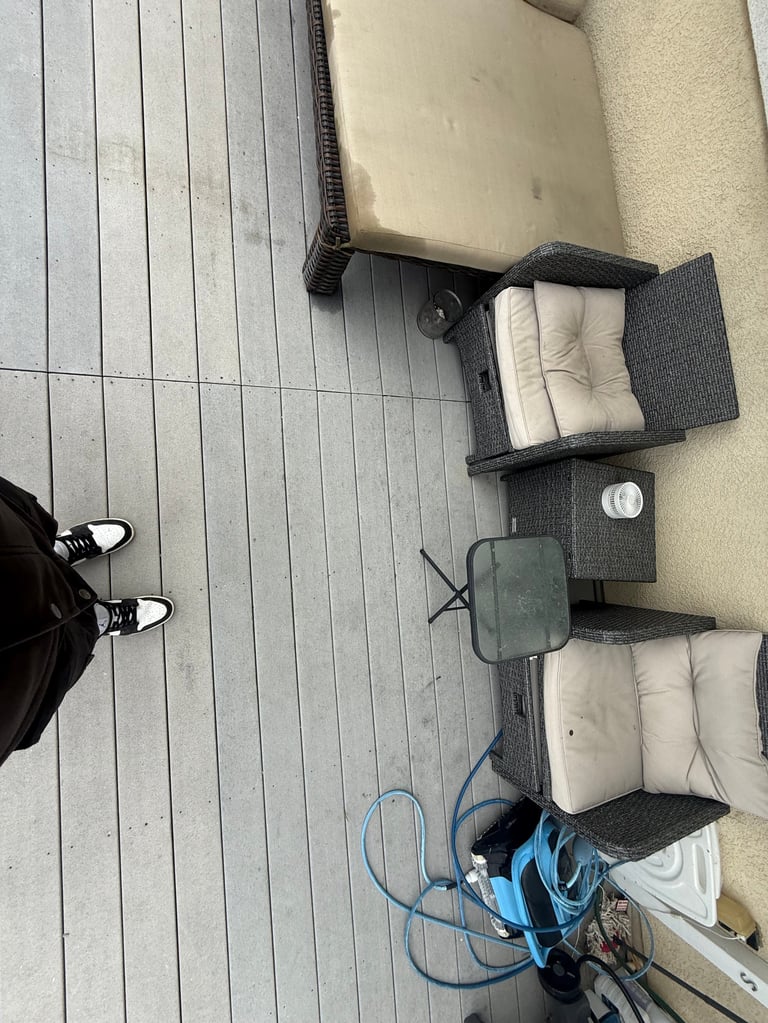 Overhead view of outdoor seating with worn cushions on deck