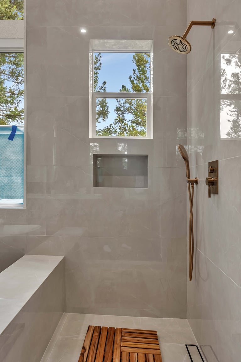 Modern shower with glass enclosure and rainfall showerhead with window views