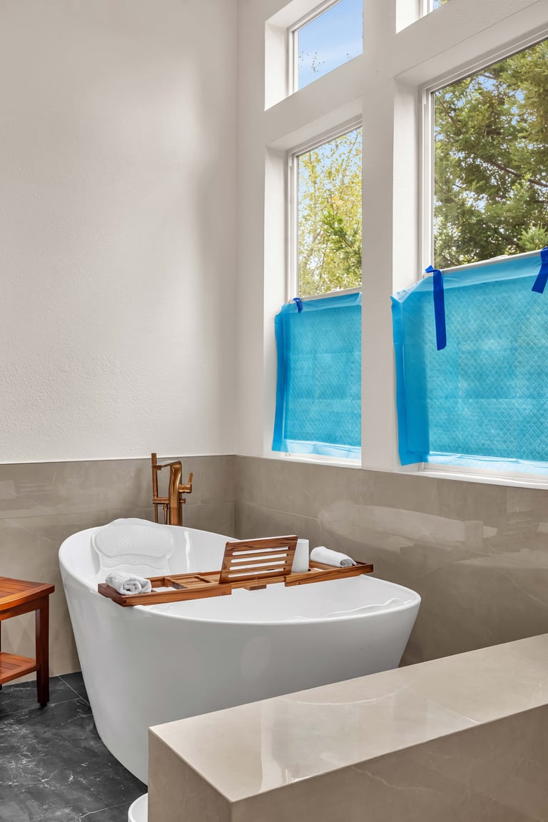 Modern bathroom with white freestanding tub and large windows